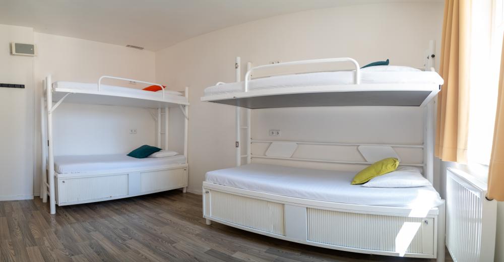 Cama en dormitorio mixto de 6 camas con baño privado