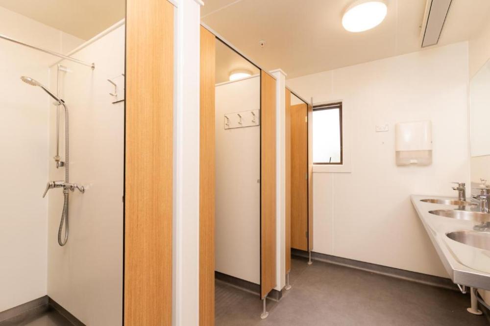 Una cama en un dormitorio femenino compartido de 8 camas - Baño compartido.