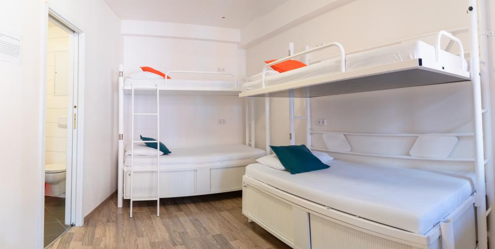 Cama en dormitorio mixto de 4 camas con baño privado