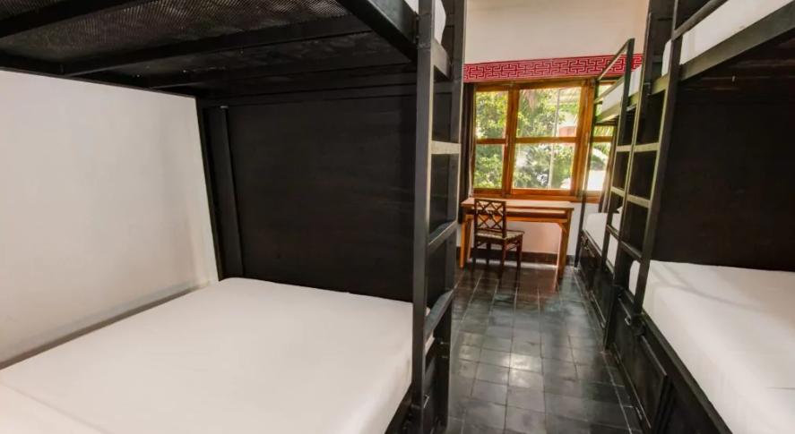 Cama en dormitorio femenino de 6 camas con baño privado.